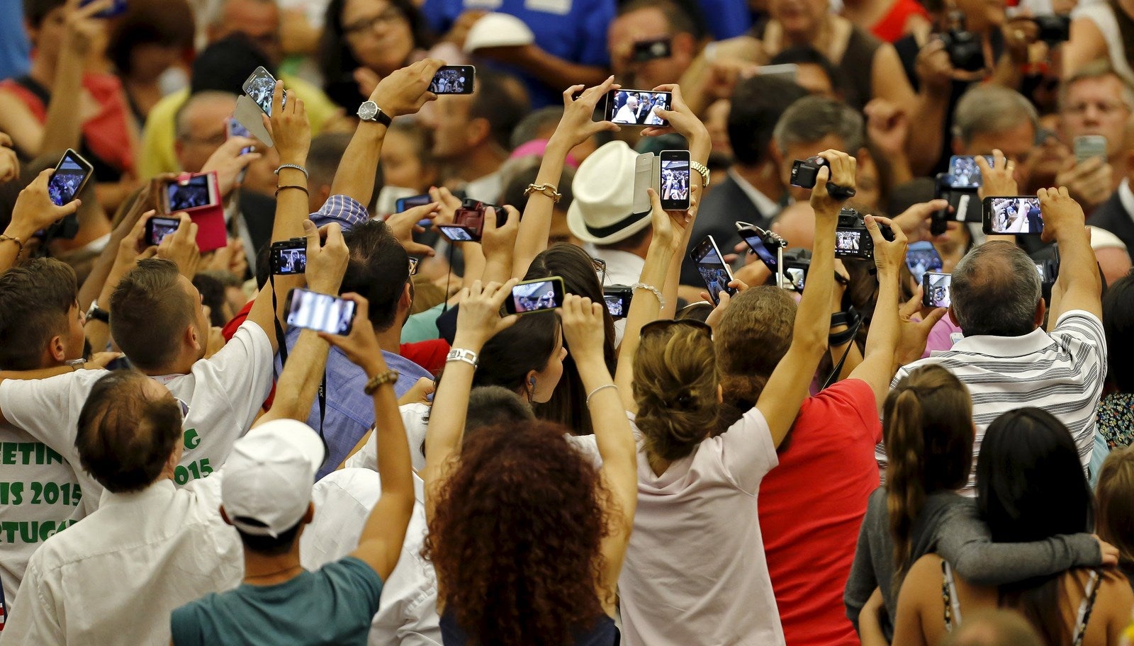 Fieles toman fotografías del papa Francisco durante su audiencia semanal en la sala Pablo VI en el Vaticano.