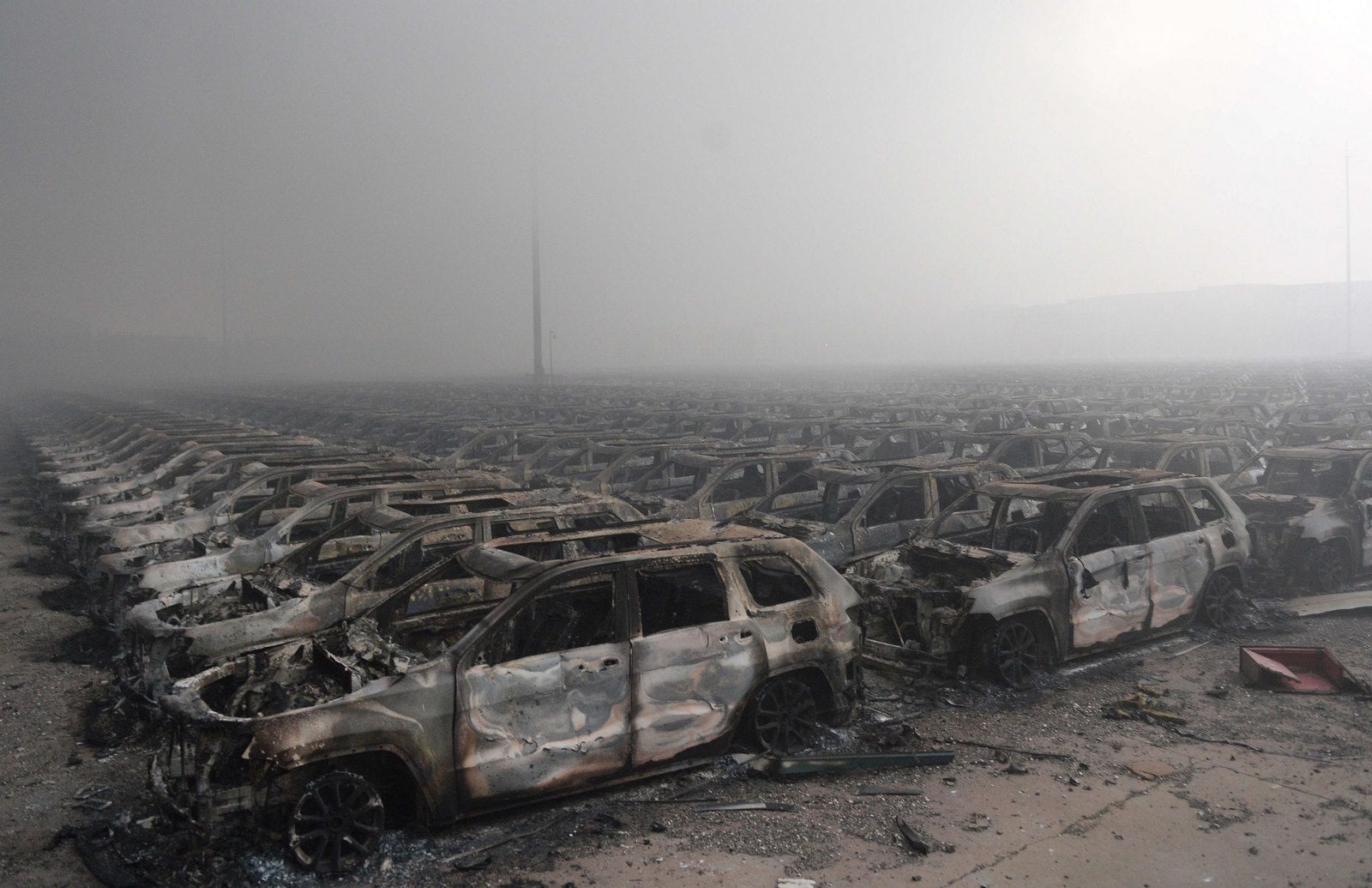 Coches quemados tras una serie de explosiones en un almacén de productos químicos alcanzaron la ciudad de Tianjin.