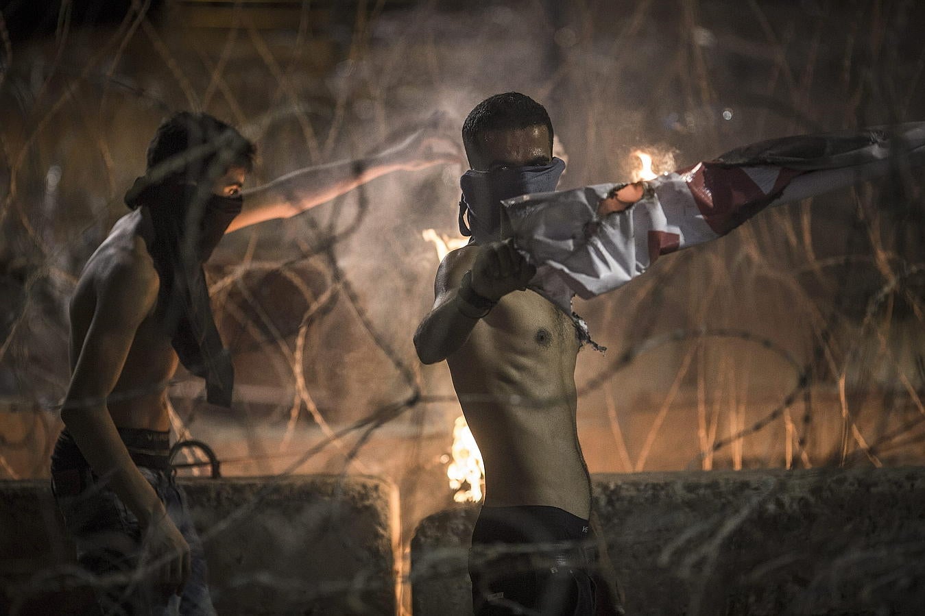 Jóvenes libaneses queman pancartas durante una protesta en el centro de Beirut, Líbano.