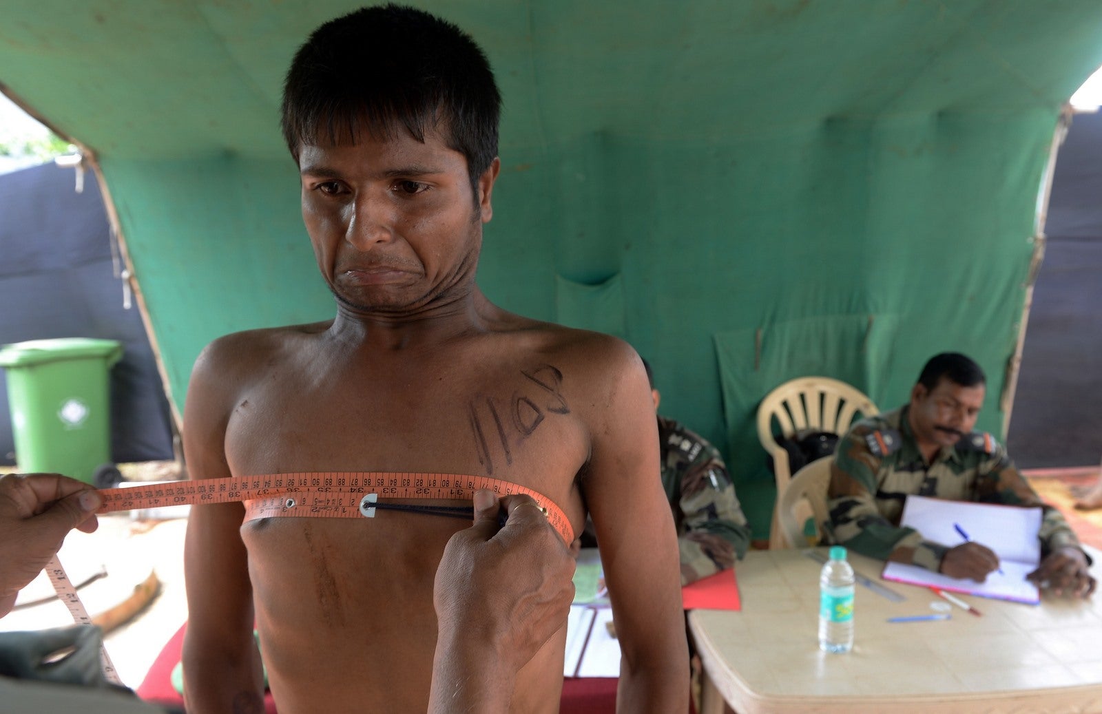 Un joven indio contiene la respiración para expandir el pecho.