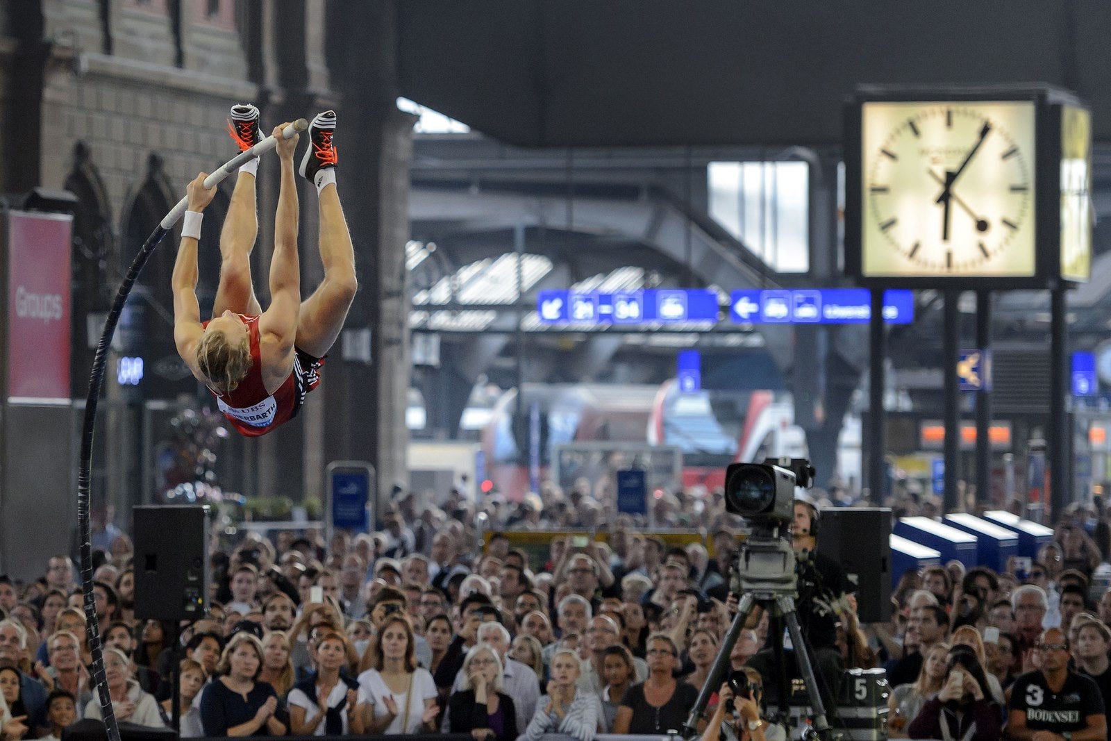 Espectadores miran como el alemán Tobias Scherbarth compite durante el evento de salto con pértiga en la estación principal de Zurich.