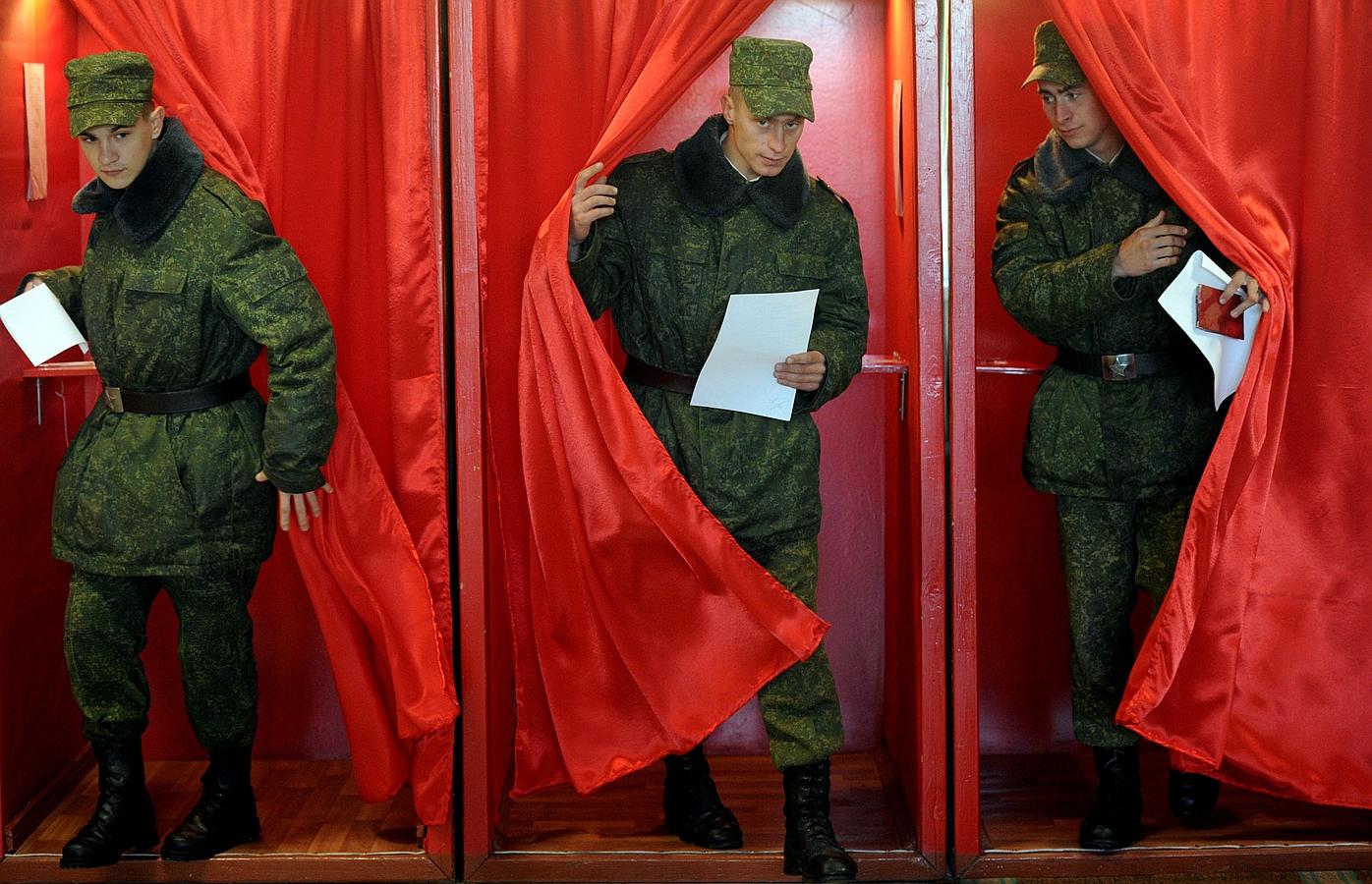 Soldados Bielorrusos dejan una cabina de votación para emitir su voto durante las elecciones presidenciales en un colegio electoral en Bogushi en Minsk.