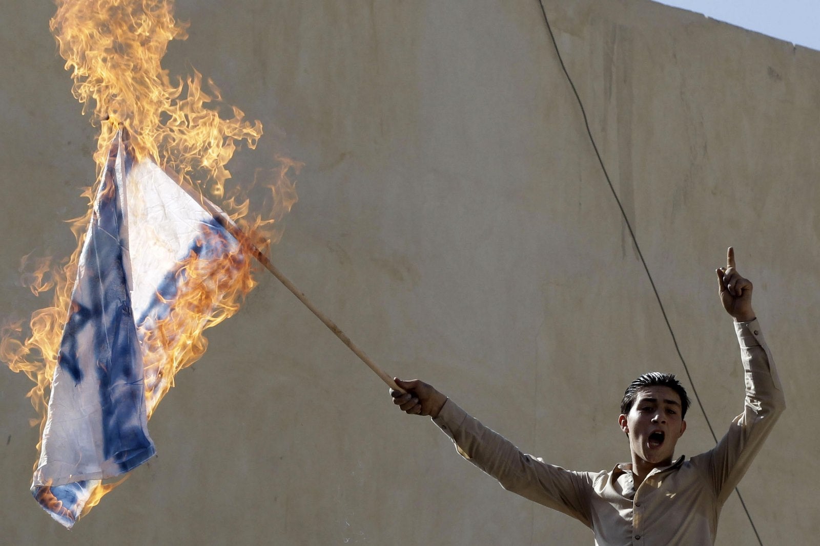 Un manifestante de Jordania quema una bandera israelí durante una manifestación cerca de la embajada israelí en la capital Amman.