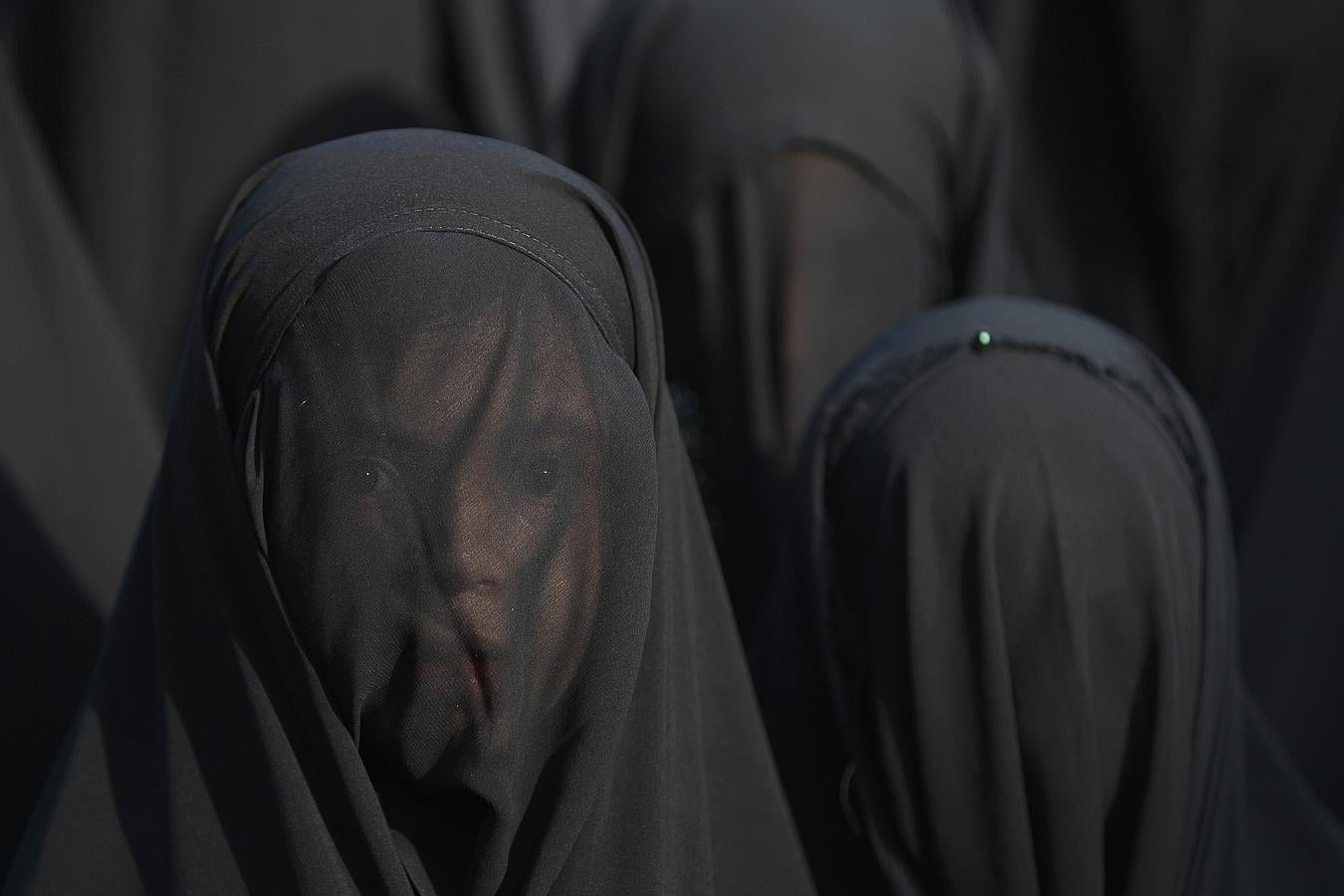 Una niña chiíta iraquí, cuyo rostro está cubierto con un velo, participa en un desfile en la preparación para el período de luto de Ashura, en el distrito norte de Bagdad de Kadhimiya.