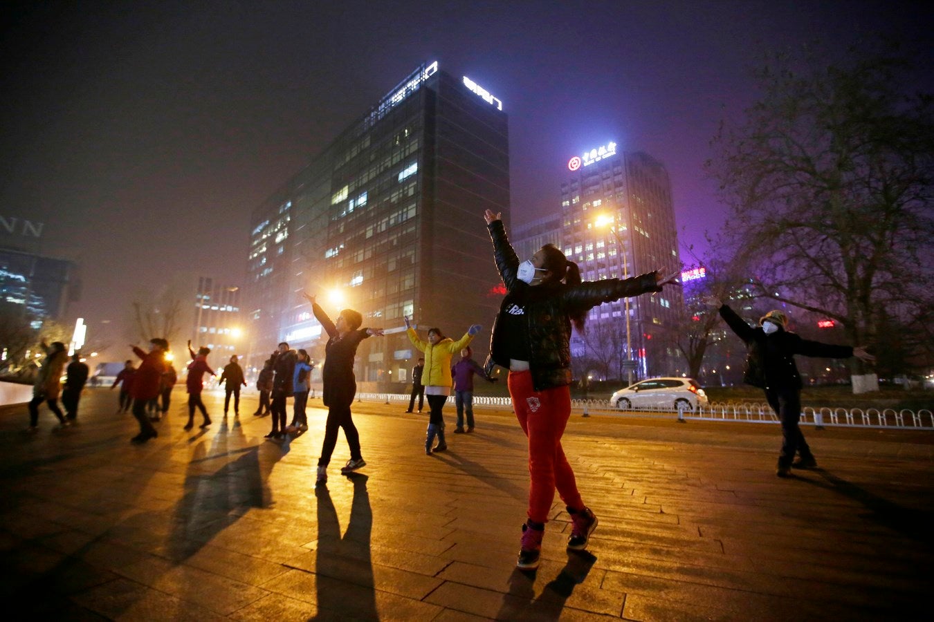 Mujeres con máscaras y otros residentes durante su ejercicio diario en medio de la fuerte contaminación en Beijing, China.