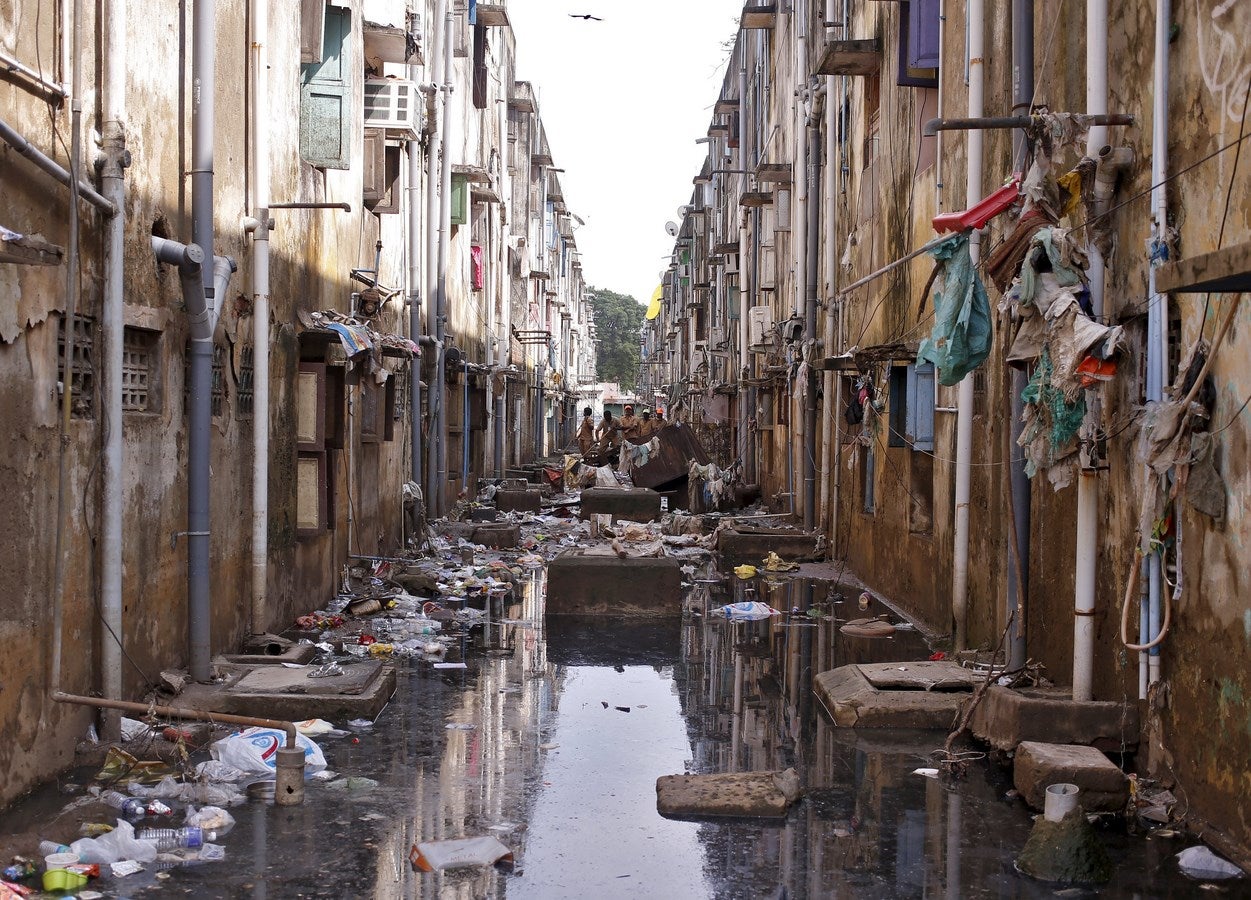 Trabajadores municipales limpian los escombros en un callejón después de las inundaciones en Chennai, India.