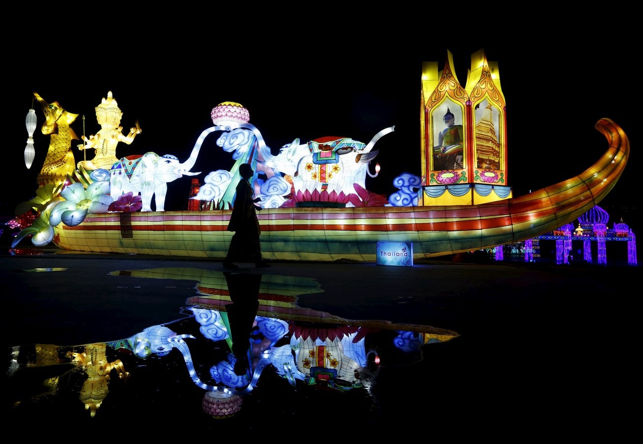 Una mujer pasa junto a una Asociación de Naciones del Sudeste Asiático (ASEAN) con pantalla de luz, parte de una exposición iluminada por más de un millón de bombillas, en Kuala Lumpur, Malasia.