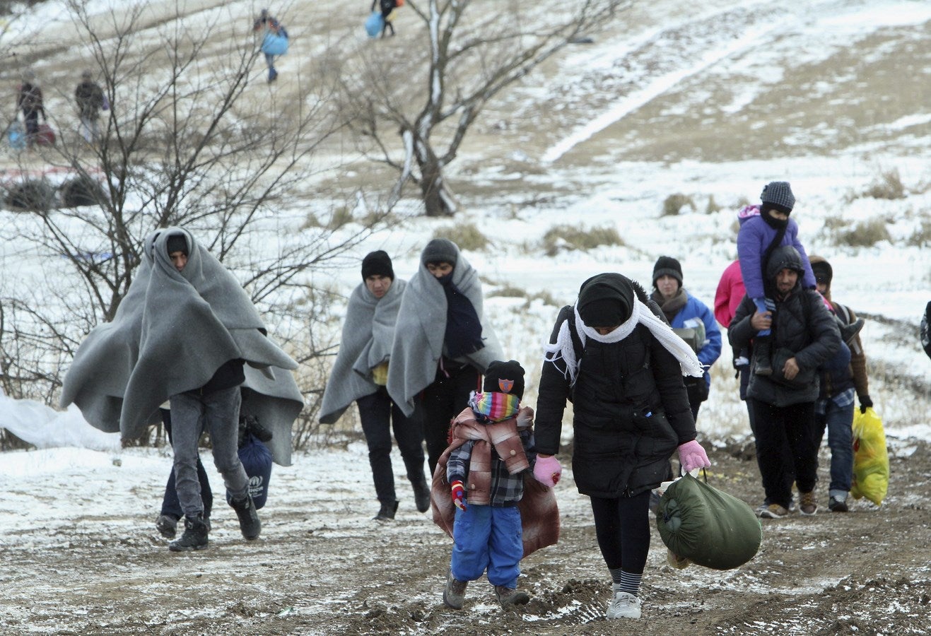 Inmigrantes a pie a través de un campo congelado después de cruzar la frontera de Macedonia, cerca del pueblo de Miratovac, Serbia.