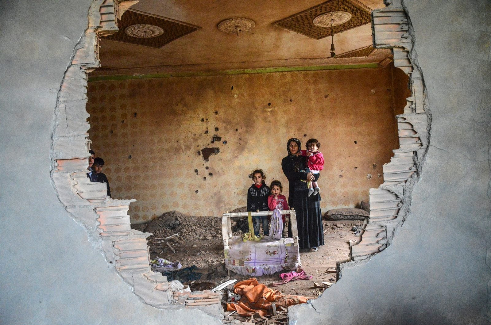 Mujeres y sus hijos están en las ruinas de la casa dañada en la ciudad kurda de Silopi, en el sureste de Turquía.