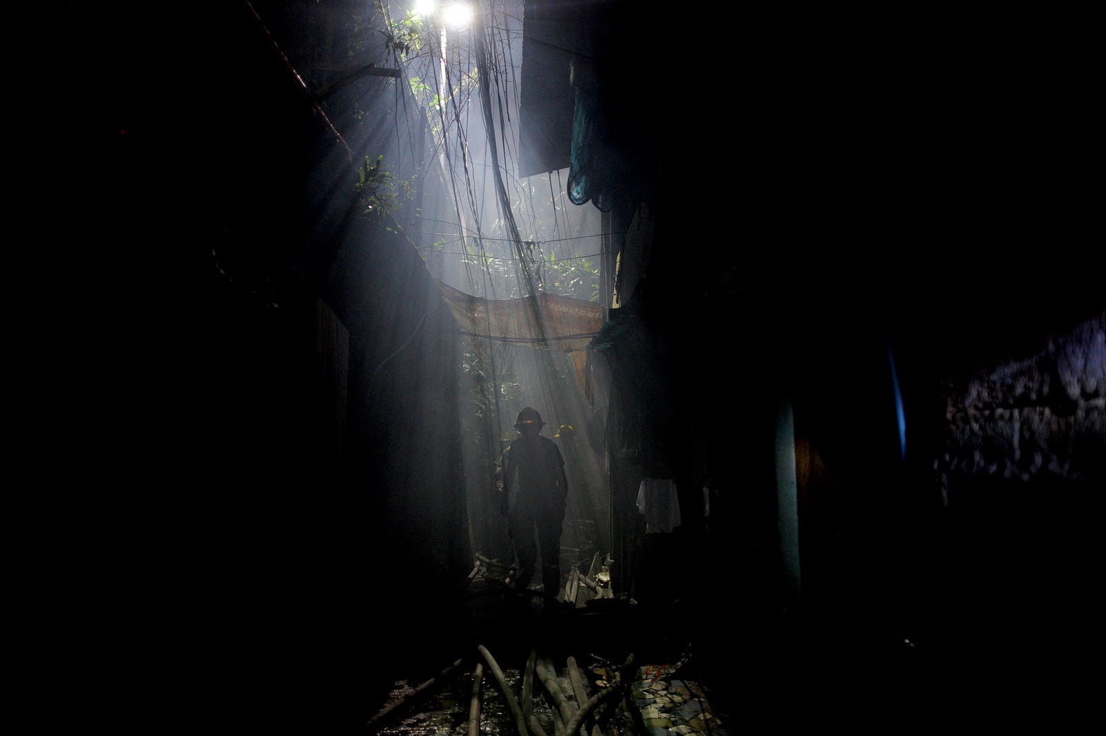 Los bomberos extinguen un incendio que arrasó una zona residencial en Manila .