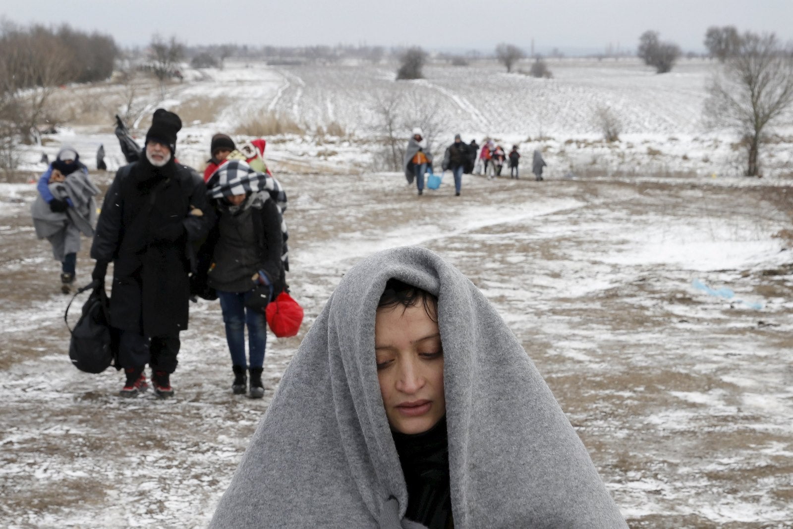 Inmigrantes a pie a través de un campo congelado después de cruzar la frontera de Macedonia, cerca del pueblo de Miratovac, Serbia.