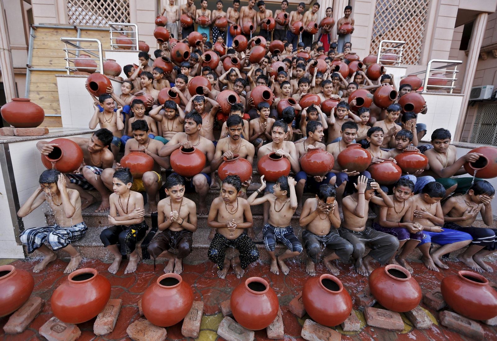 Los estudiantes tienen vasijas de barro llenas de agua para tomar un baño sagrado antes del festival Magh Mela durante una ceremonia en Ahmedabad, India.