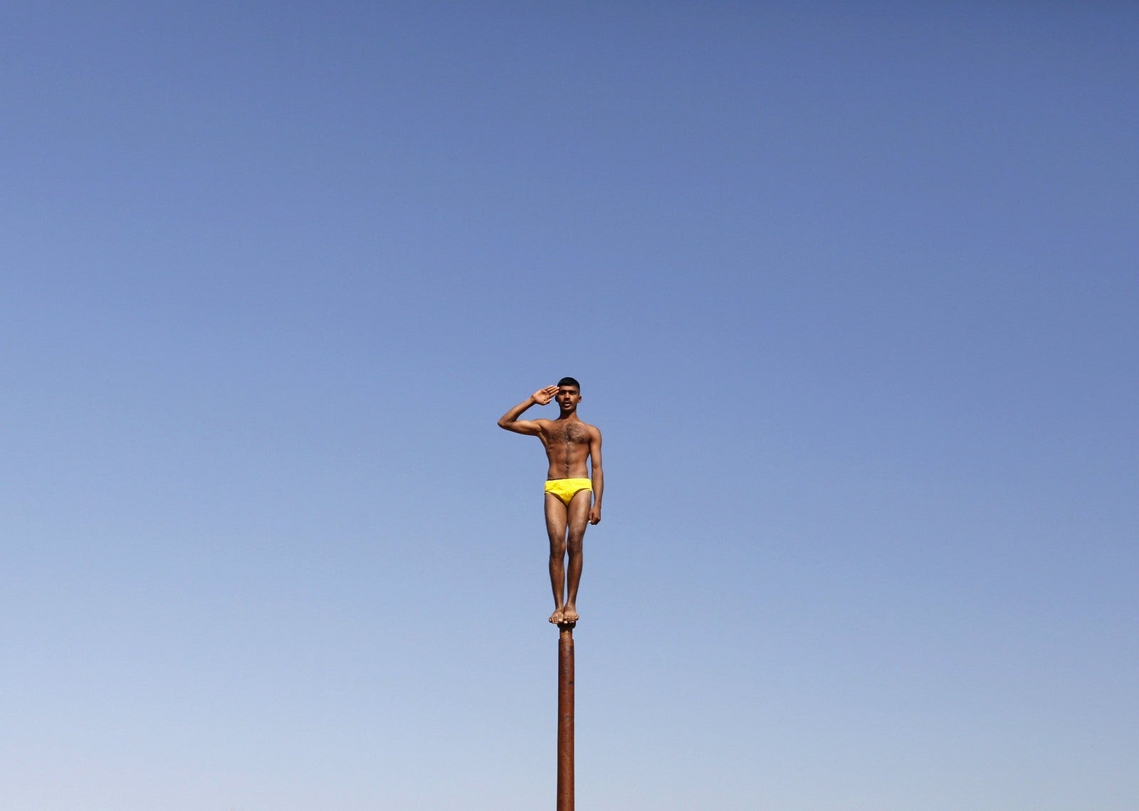 Un soldado del ejército indio realiza "Malkhamb" (gimnasia tradicionales de la India), durante un programa de sensibilización para atraer a los jóvenes de unirse a las fuerzas armadas en la víspera del Día de la República de la India en Gandhinagar, en el estado occidental de Gujarat, India.