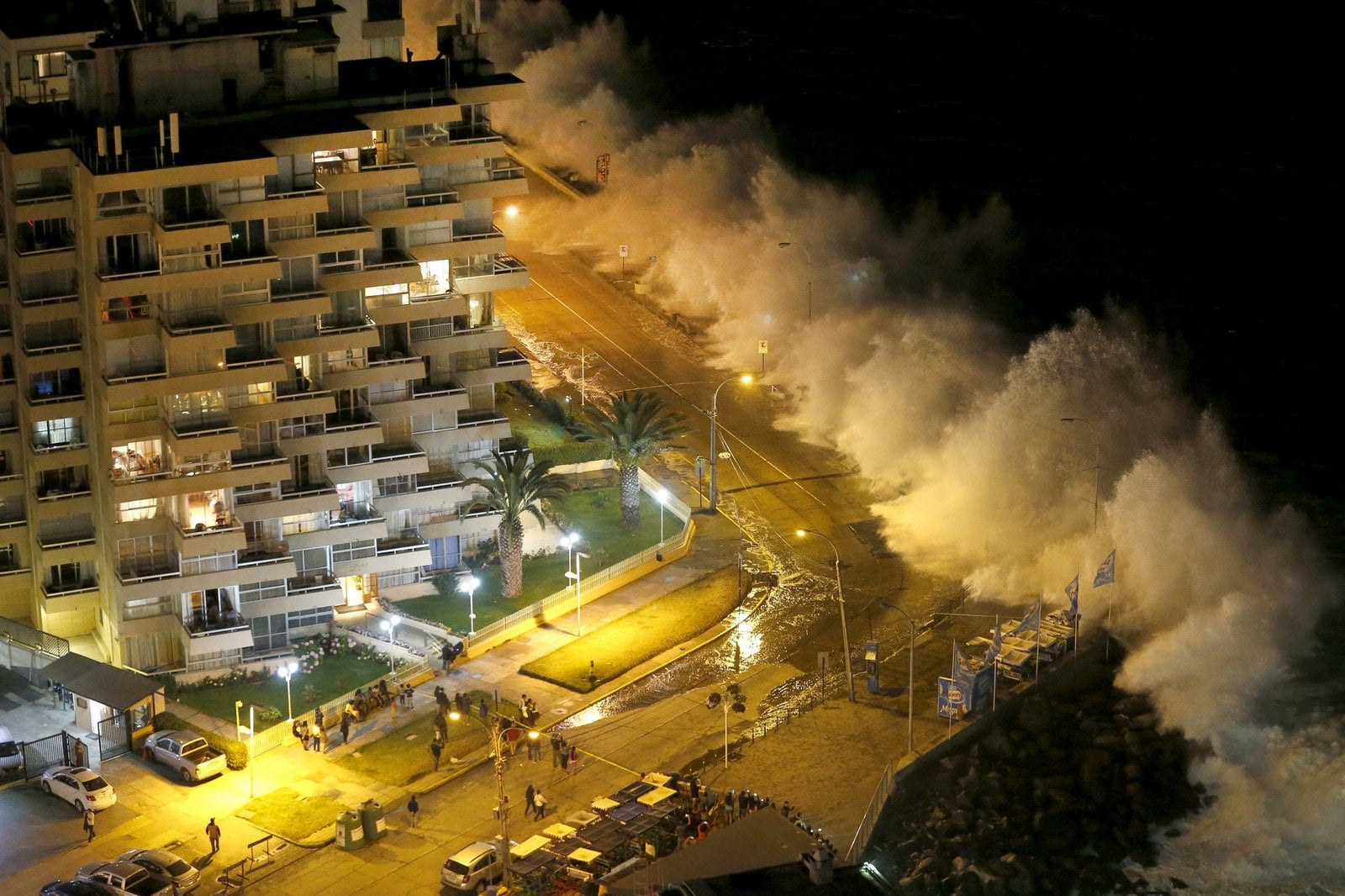 Los turistas observan altas olas del Océano Pacífico golpeando la costa en la ciudad de Viña del Mar, Chile.