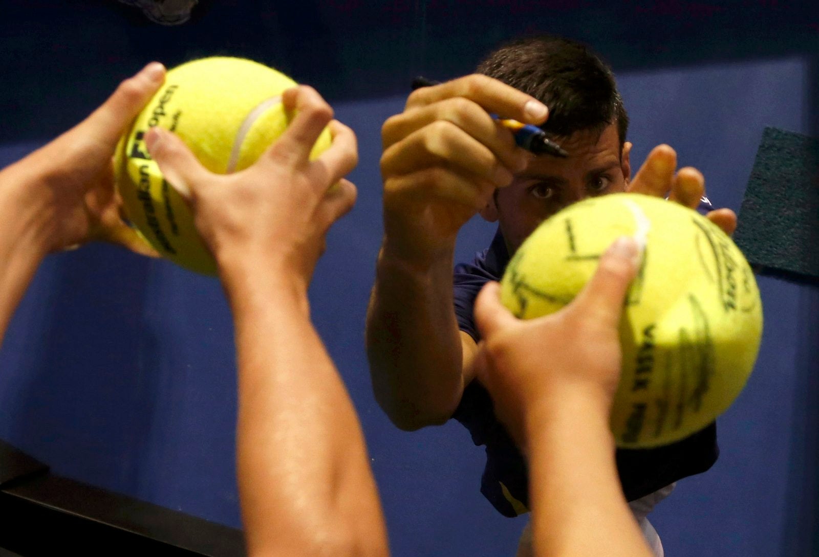 El serbio Novak Djokovic firma autógrafos después de ganar su partido de cuartos de final ante el japonés Kei Nishikori en el torneo de tenis Abierto de Australia en Melbourne Park.