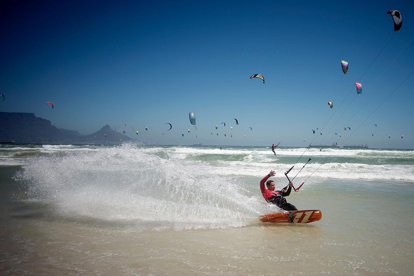Un surfista gira hacia el mar durante el Kite surf Armada, en la que los participantes están tratando de romper el récord Guinness Mundial de participantes en la playa de Tableview, en Ciudad del Cabo.