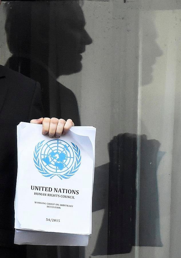 El fundador de WikiLeaks, Julian Assange, se ve reflejado en una puerta de cristal que hace un discurso, mientras que la celebración de una copia de una resolución de la ONU, en el balcón de la Embajada del Ecuador, en el centro de Londres, Gran Bretaña.