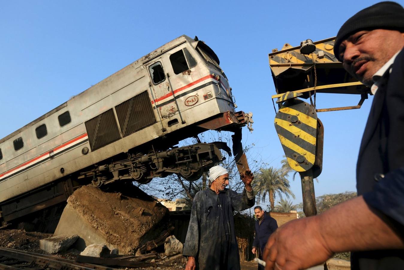 Trabajadores egipcios eliminan los restos de un choque de trenes en Beni Suef, al sur de El Cairo.