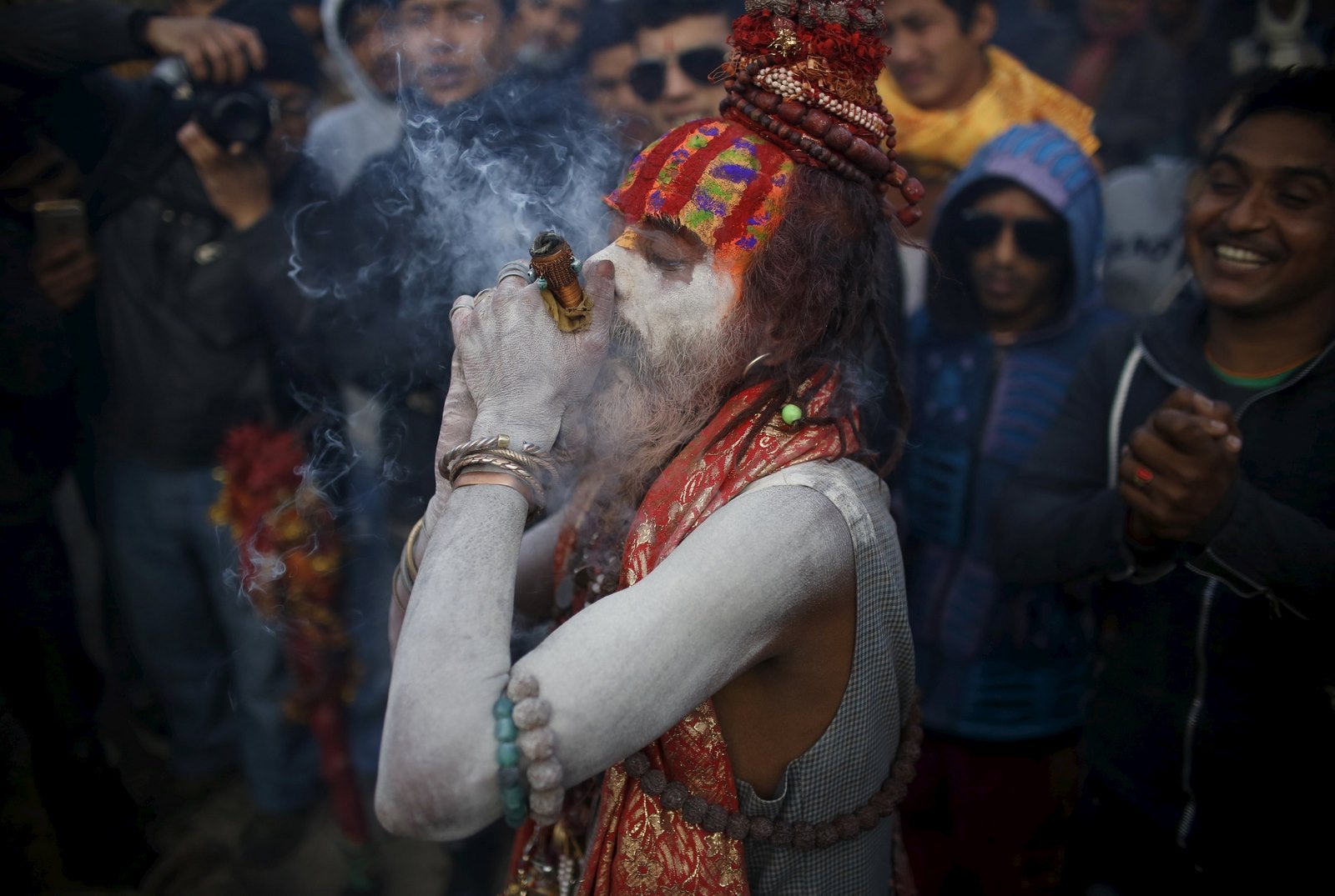 Un hombre hindú santo o sadhu, untado con cenizas fuma marihuana en un chillum durante el festival de Shivaratri en las instalaciones del templo de Pashupatinath en Katmandú, Nepal.