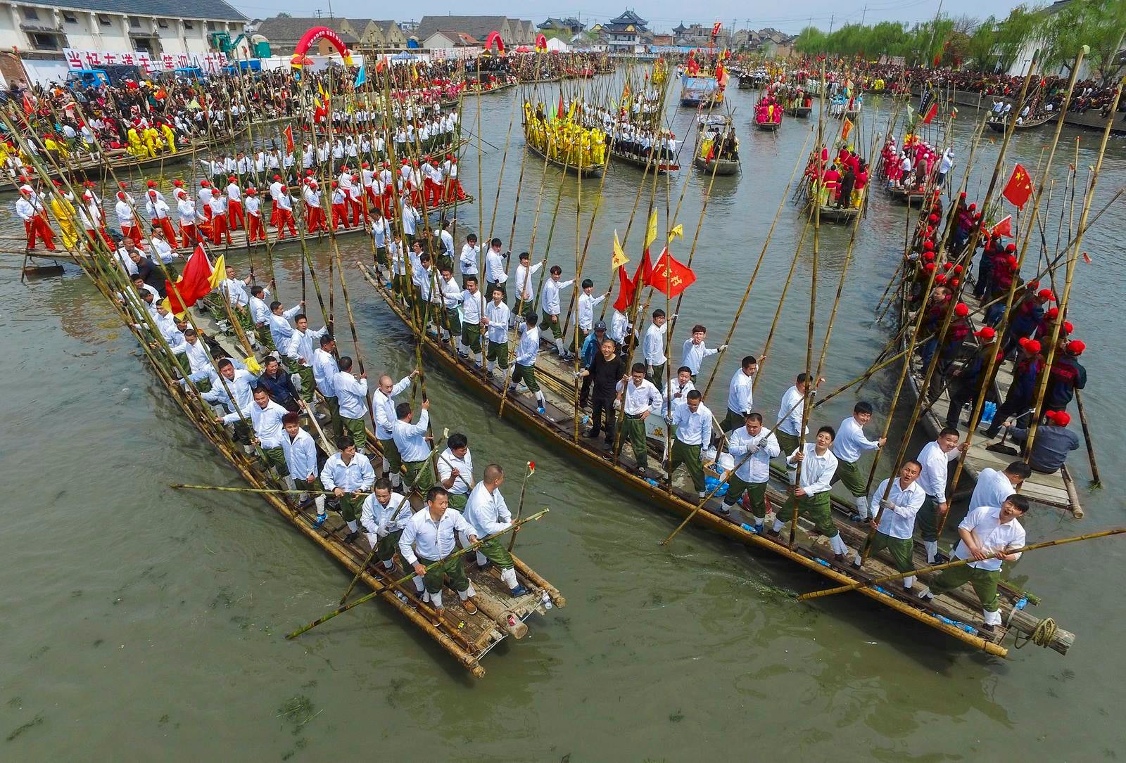 Los participantes tienen cañas de bambú a medida que impulsan los barcos durante la celebración del tradicional Qingming Festival, también conocida como Tumba de barrido Festival, en Taizhou, provincia de Jiangsu, China