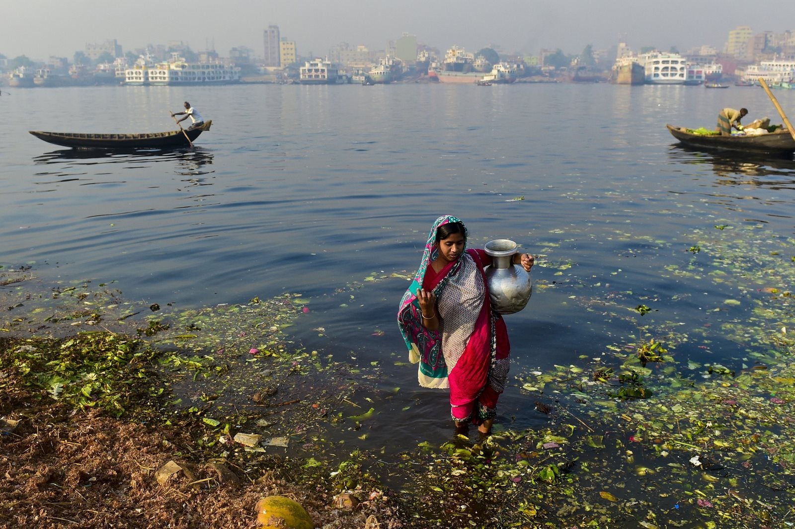 Una mujer de Bangladesh recoge el agua contaminada para ser utilizados en un mercado de vegetales procedentes de la Buriganga en Dhaka.
