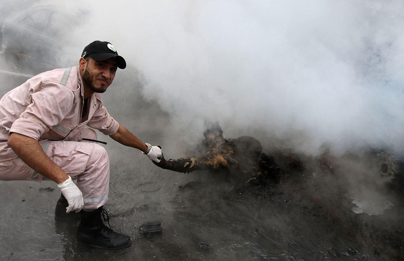 Un miembro de los servicios de emergencia del Líbano elimina el cuerpo del funcionario palestino Fathi Zeidan de la escena de la explosión de una bomba en la ciudad portuaria de Sidón.