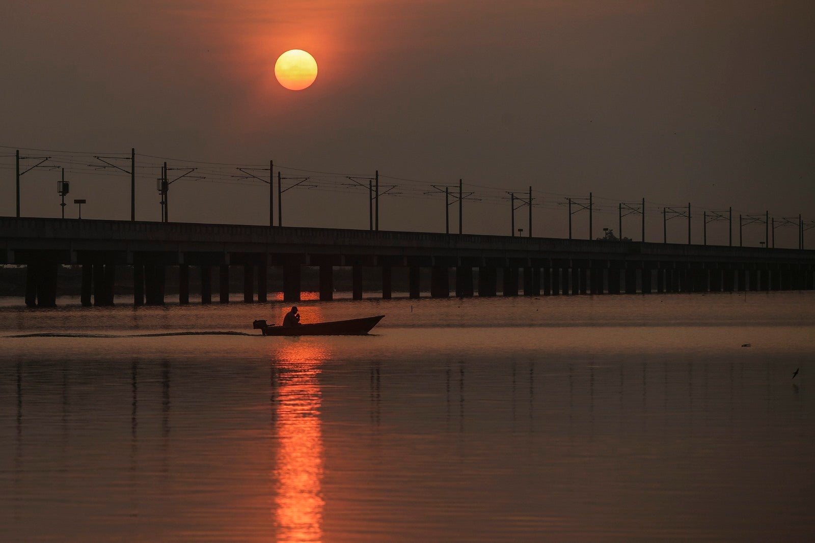 Un hombre pesca en una barca durante el amanecer en el embalse Bukit Merah, Malasia. La sequía que atraviesa el país se considera crítica mientras que el fenómeno "El Niño" está secando el embalse. Según las autoridades malasias, varios estados han reducido la cantidad de agua tratada para los hogares.