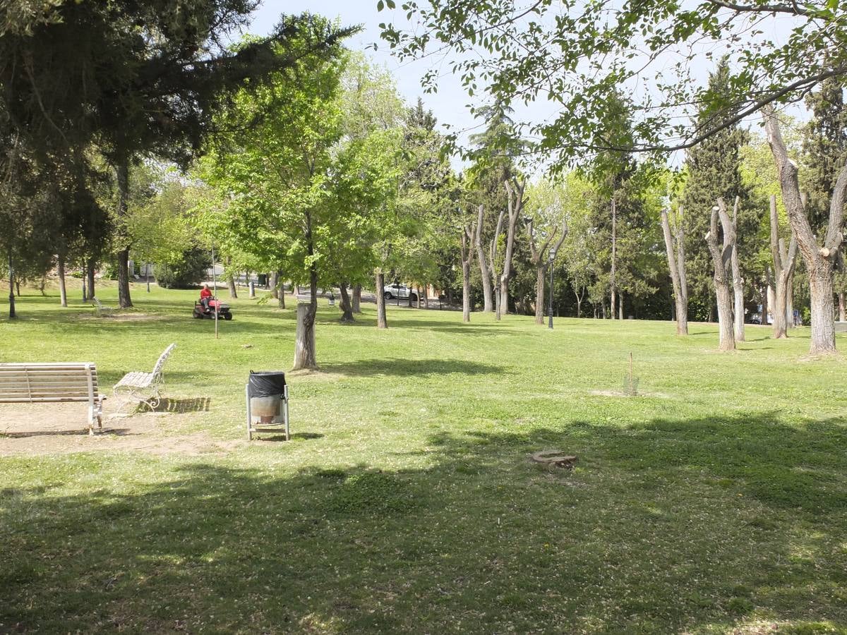 Un empleado de la urbanización arregla el parque.