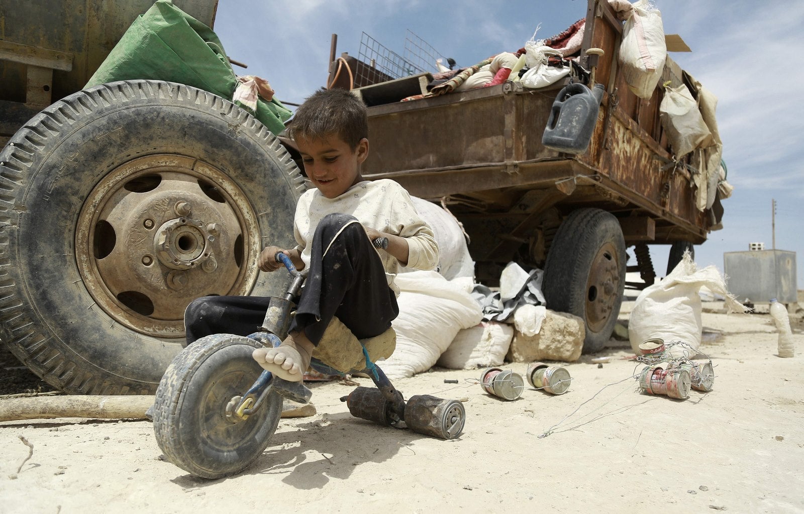 Un niño iraquí juega con un triciclo improvisado en un campo de refugiados en al-Hawl.