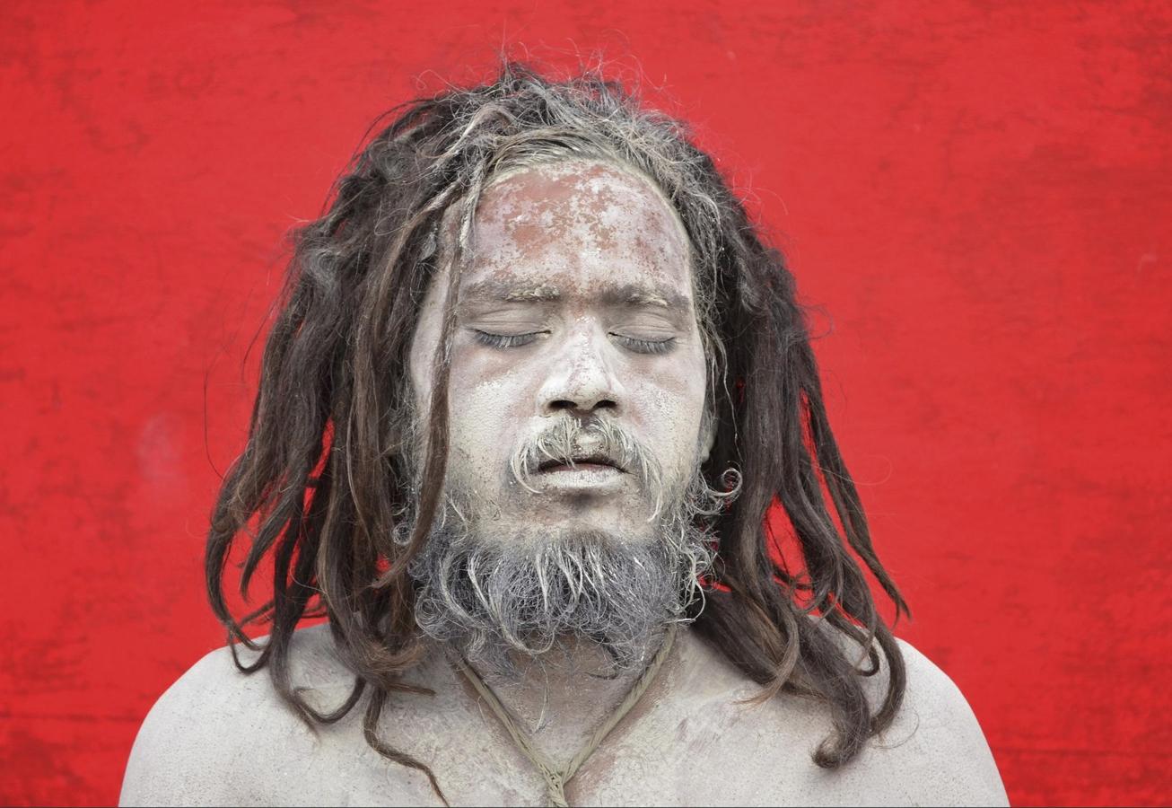 Un Sadhu o una holylam hindú, con su cara cubierta de ceniza, ora antes de registrarse para la peregrinación anual a la capilla de la cueva de Amarnath, en un campamento base en Jammu