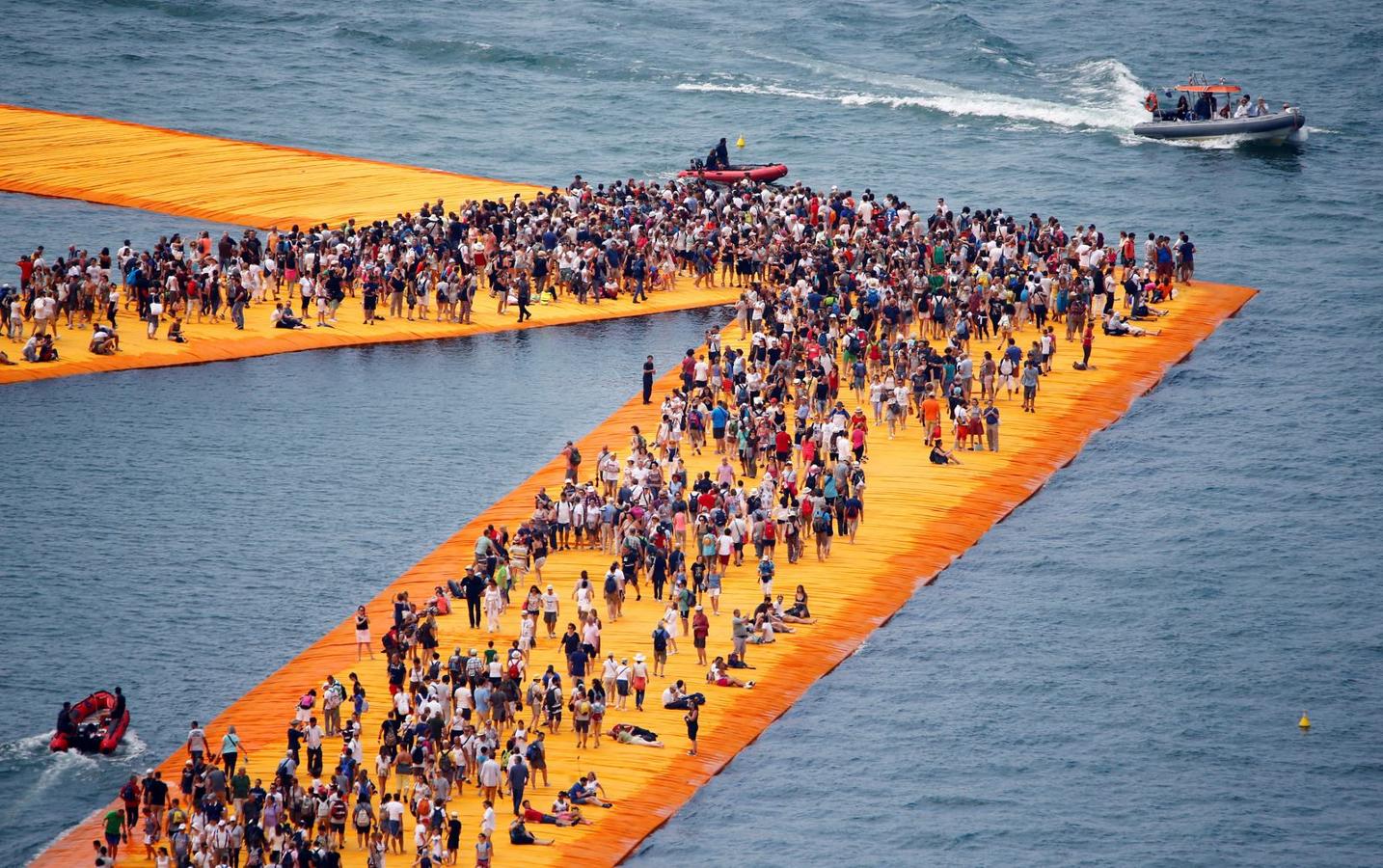 La gente camina en la instalación 'The Floating Muelles "por el artista de origen búlgaro Christo Vladimirov Yavachev, conocido como Christo, cerca de Sulzano, el norte de Italia.