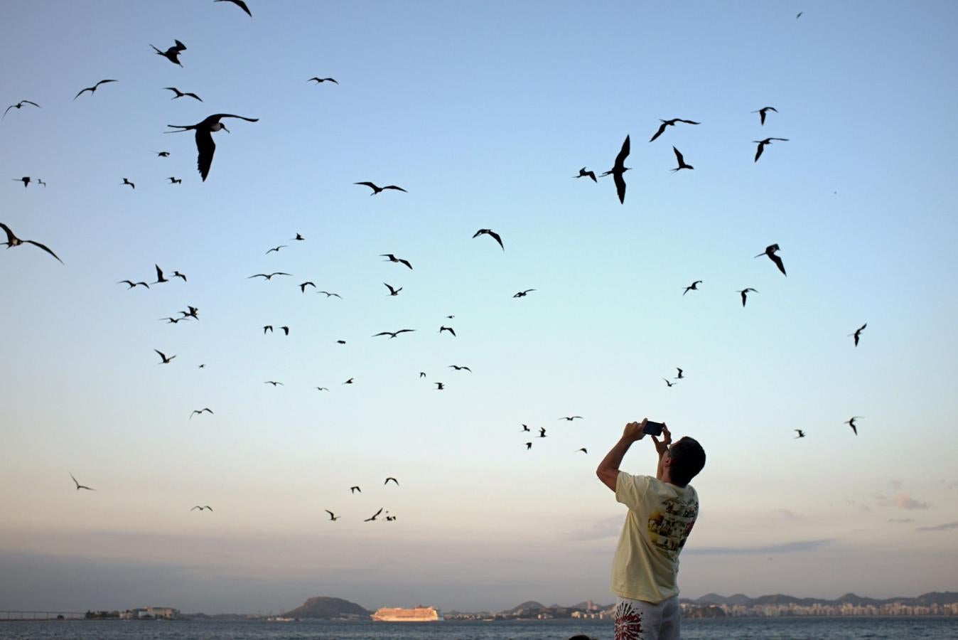 Un hombre fotografía fragatas en la playa de Flamengo, en Río de Janeiro.