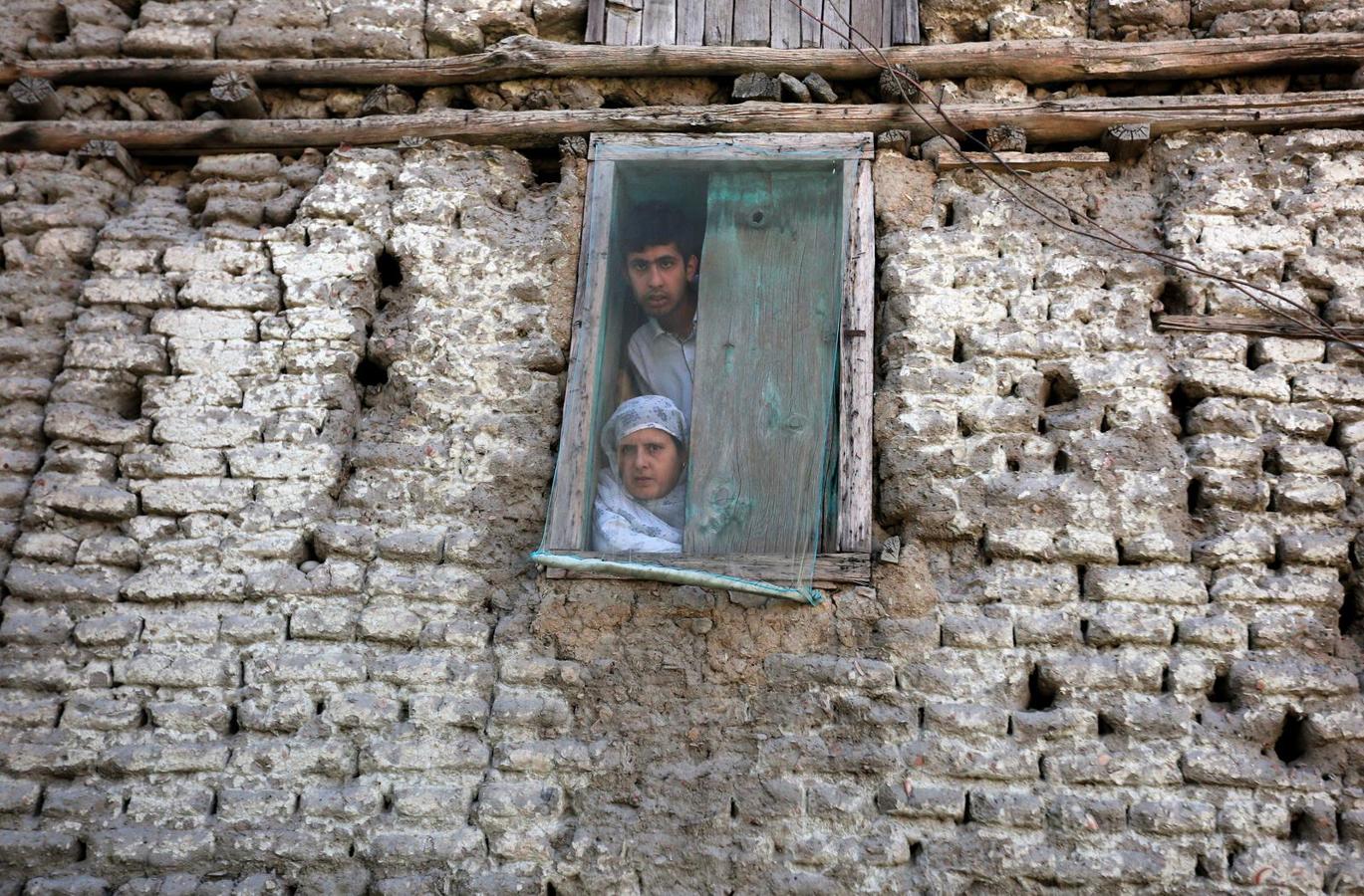 La gente mira desde la ventana mientras una protesta contra los recientes asesinatos en Cachemira, en las afueras de Srinagar.