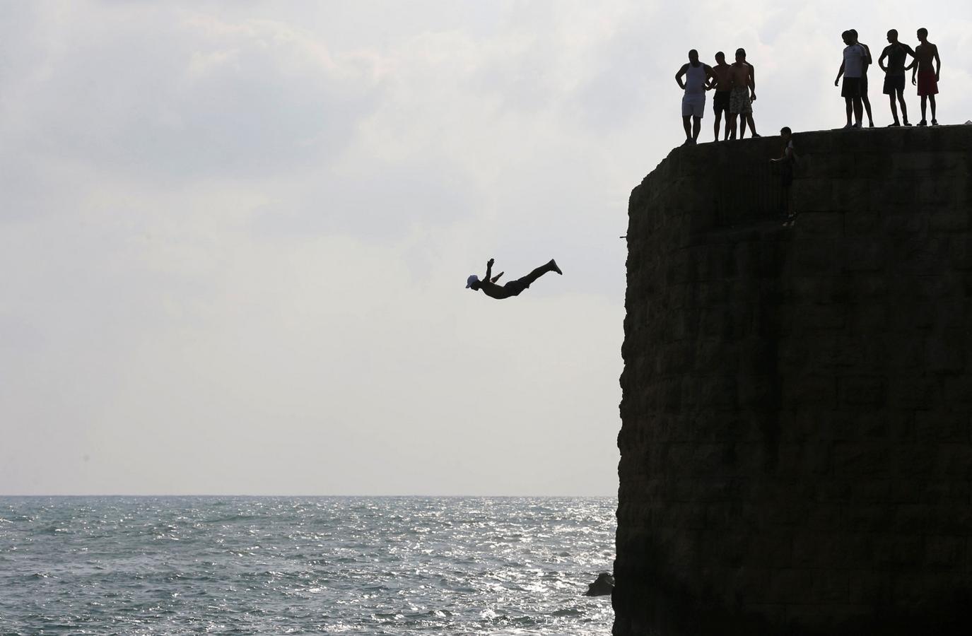 Un hombre salta al mar Mediterráneo en la ciudad norteña israelí de Acre.