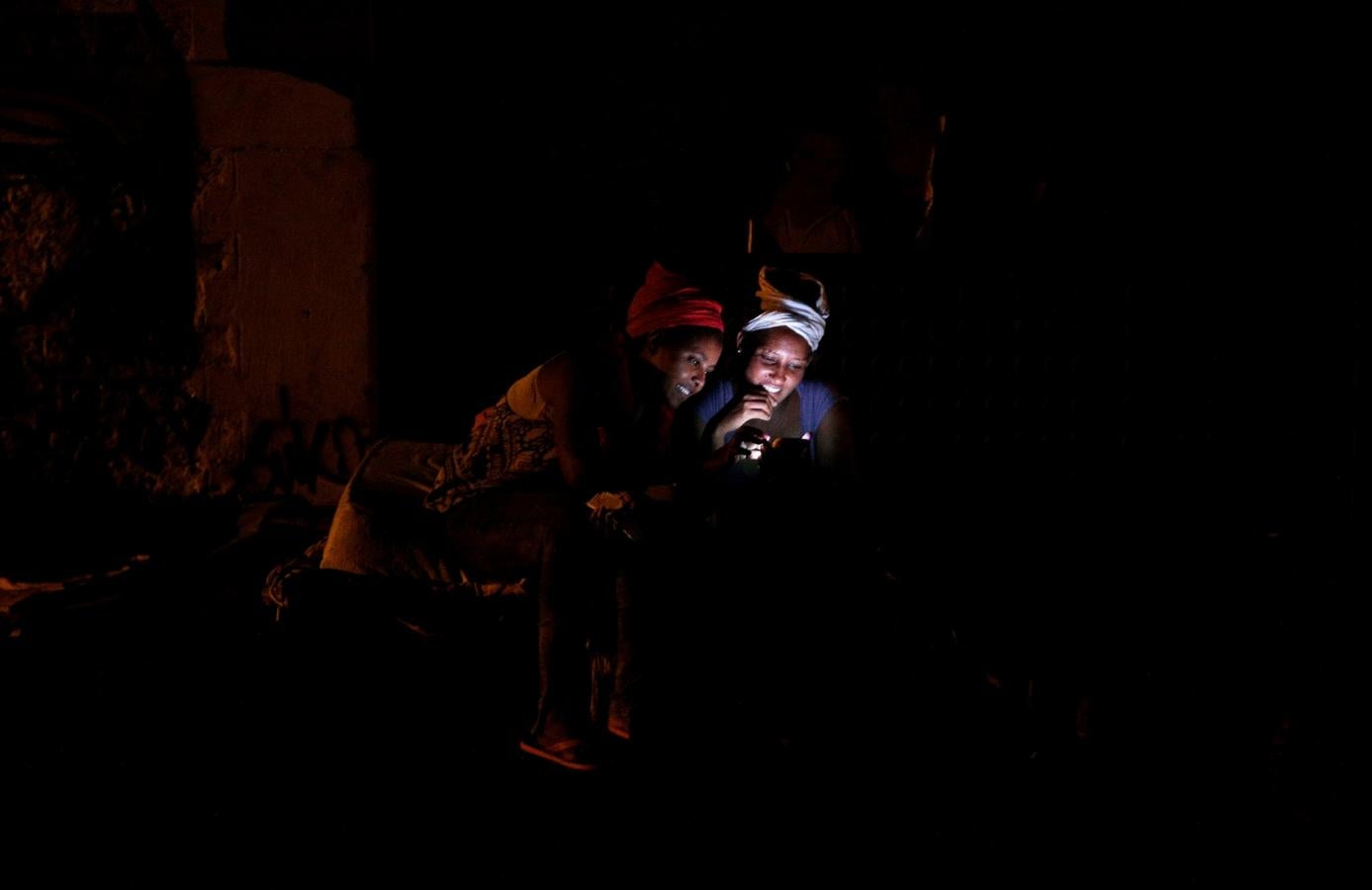 Una emigrante comprueba su teléfono en un campamento improvisado en Via Cupa en el centro de Roma.