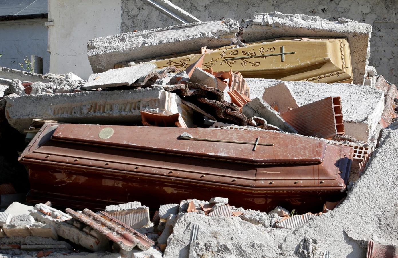 Ataúdes cubiertos por los escombros se ven en un cementerio después de un terremoto en Sant 'Angelo, cerca de Amatrice, el centro de Italia