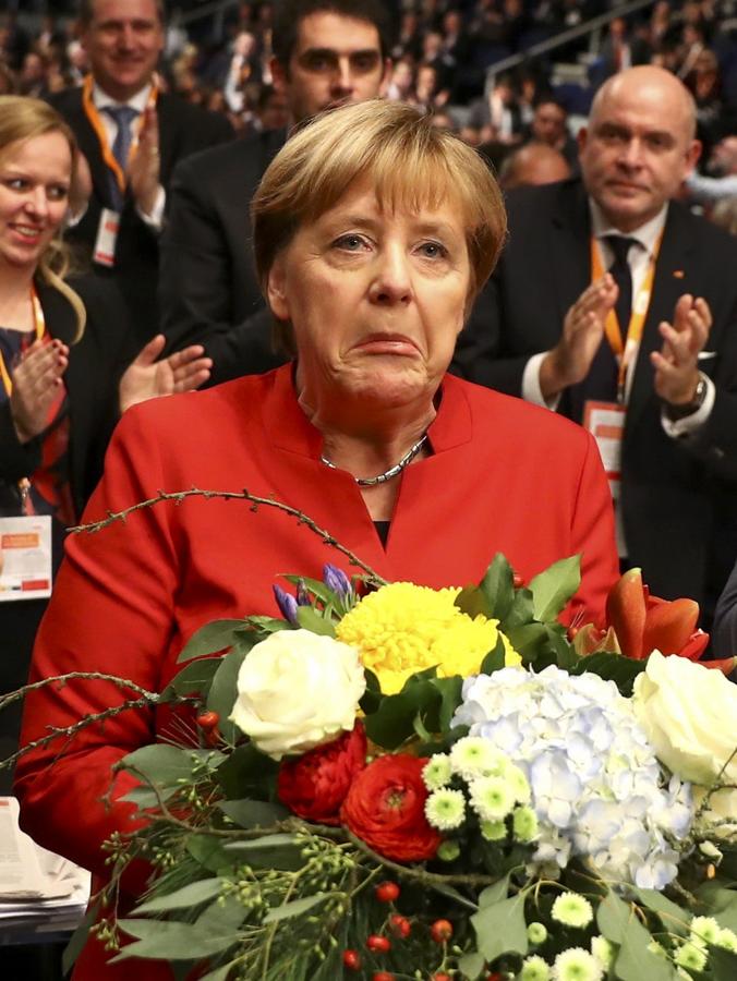 La canciller alemana y líder del partido conservador de la Unión Demócrata Cristiana (CDU) Angela Merkel recibe flores tras ser reelegida como presidenta en la convención del CDU en Essen, Alemania