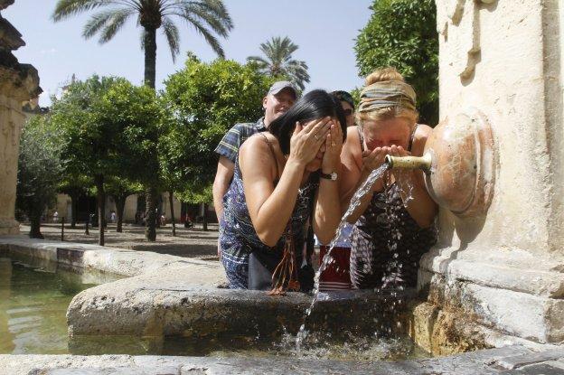 Unas mujeres se refrescan en una fuente en plena ola de calor 