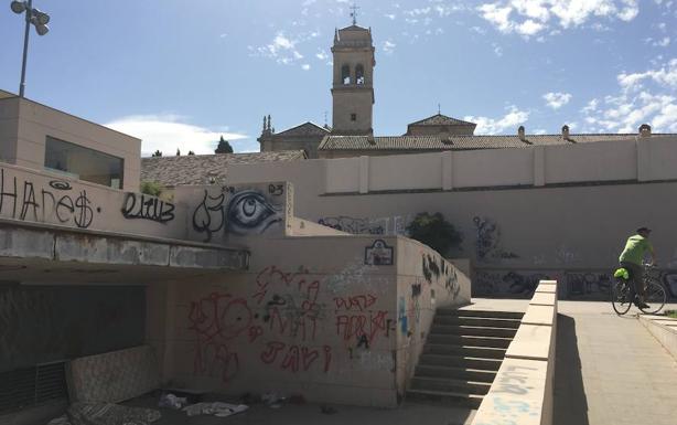 Imagen principal - Grafitis, colchones y basura en las inmediaciones de la plaza, a la sombra del monasterio de San Jerónimo.