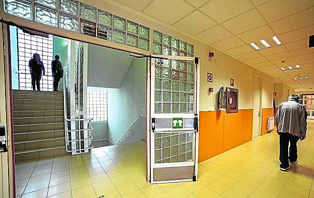 Un señor mayor con una enfermedad mental camina por el pasillo de un psiquiátrico. 