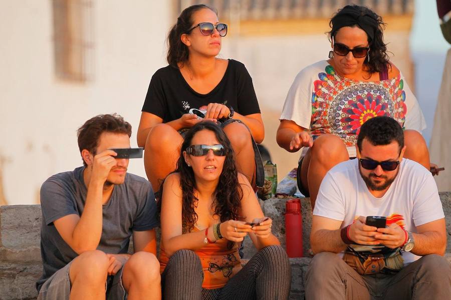 Granada se convirtió ayer en el mejor balcón para observar el eclipse parcial de sol. Numerosos granadinos se echaron a la calle en lugares como el Mirador de San Miguel Alto o el de San Nicolás para disfrutar del fenómeno, que no se volverá a repetir de nuevo hasta dentro de siete años