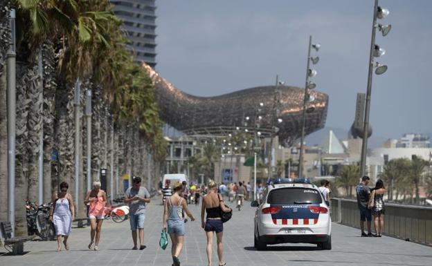 Turistas caminan por el paseo marítimo de Barcelona.