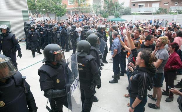 Policías paran a los manifestantes el 1-O.