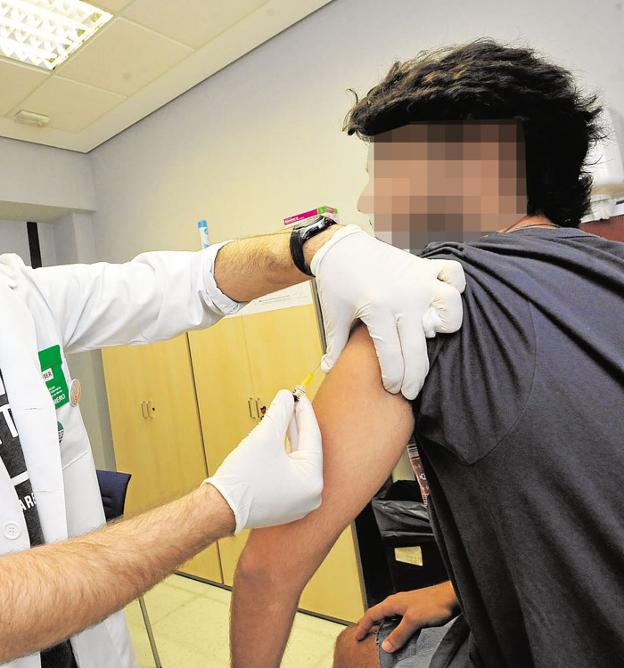 Un joven recibe una vacuna en el centro de vacunación de un hospital público.