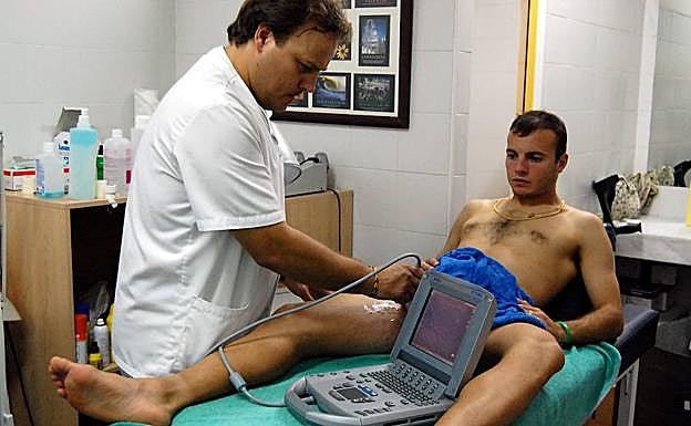 Prueba diagnóstica a un futbolista mediante un ecógrafo portátil. 