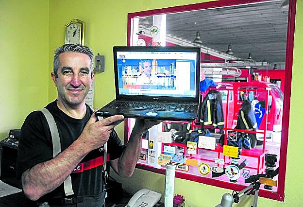 Luis muestra en el parque de bomberos la imagen de una entrevista reciente que le hicieron en televisión. :: brígido