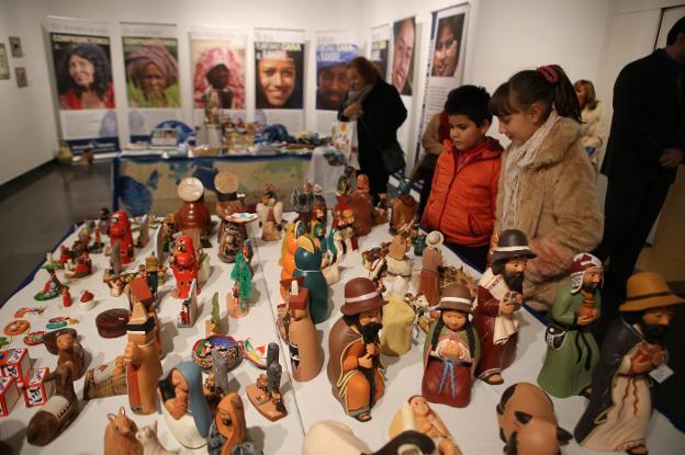 Dos niños observan figuras de un Belén en la exposición solidaria 'Manos Unidas con África'.