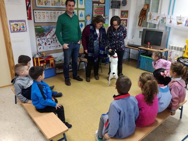 El alcalde y la concejala, con uno de los perros en el aula del colegio.