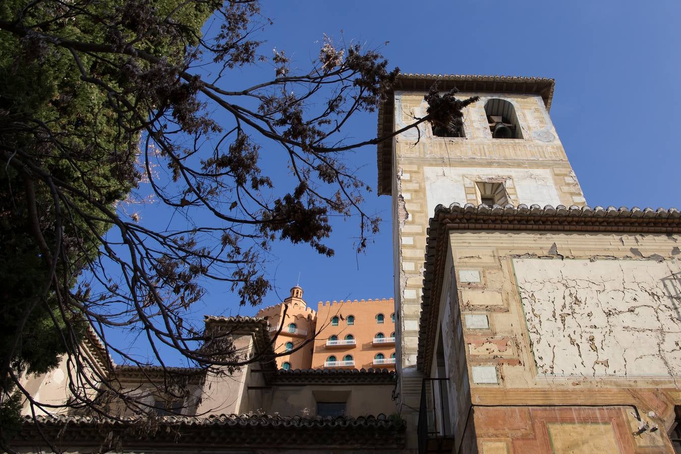 La fachada de la torre de la iglesia de San Cecilio, con el hotel Alhambra Palace detrás