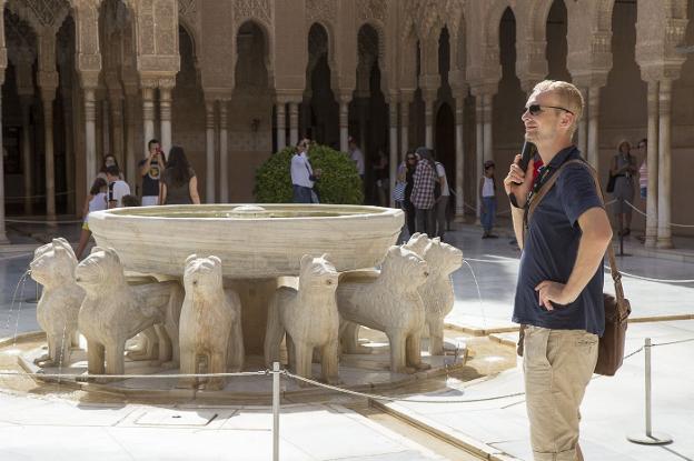 Un turista usa una audioguía para recorrer el monumento nazarí. 